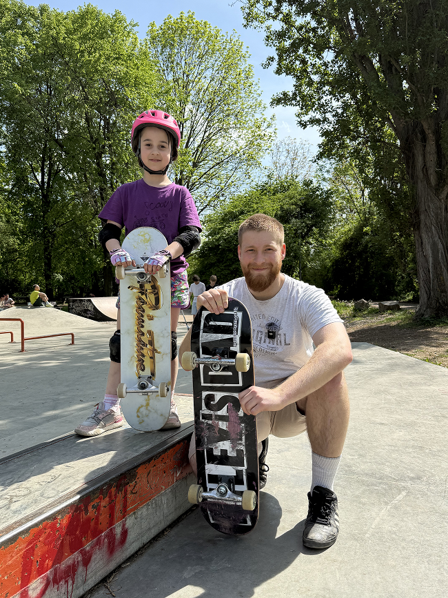 Trenér sk8mate s dětmi ve skateparku